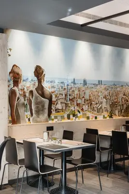 a restaurant with a large painting on the wall at Hotel Travessera in Barcelona
