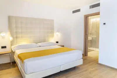 a bedroom with a large bed and a bathroom at Caledonian in Barcelona
