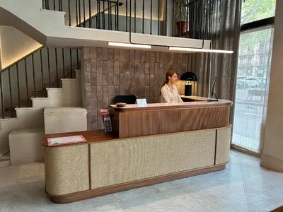 a woman sitting at a reception desk in a lobby at Caledonian in Barcelona