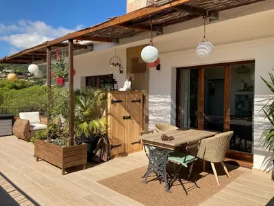 a patio with a wooden table and chairs at Cozy place, big roof terrace & spectacular views. in Cabrils
