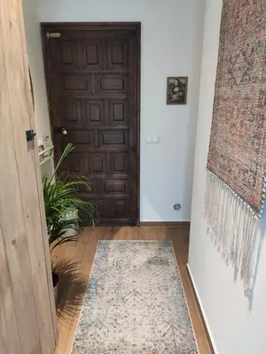 a hallway with a door and a rug on the floor at Cozy place, big roof terrace & spectacular views. in Cabrils