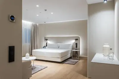 a white bedroom with a bed and a table at Royal Ramblas in Barcelona