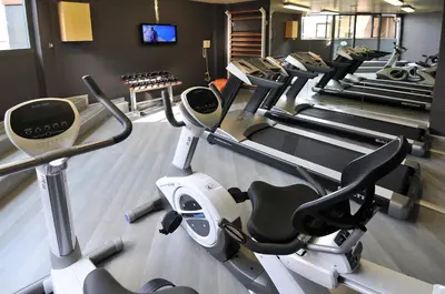 a gym with a bunch of cardio machines in it at Hotel Barcelona Universal in Barcelona