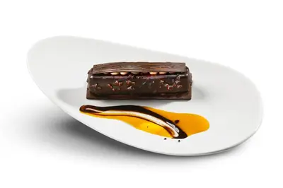 a white plate with a chocolate cake and a banana at HCC Montblanc in Barcelona