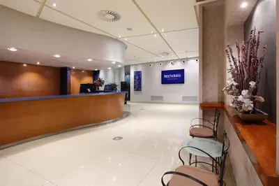 a lobby of a hotel with a reception desk and chairs at HCC Montblanc in Barcelona
