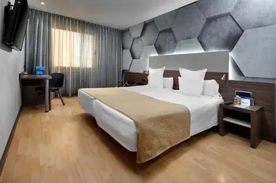 a hotel room with a large bed and a desk at HCC Montblanc in Barcelona