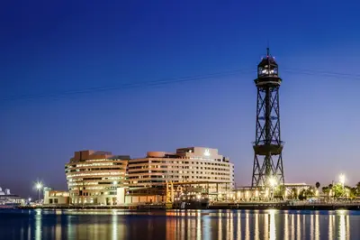 a building with a tower next to the water at Eurostars Grand Marina Hotel GL in Barcelona