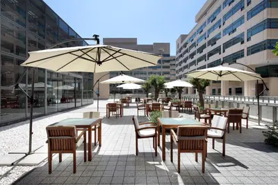 a patio with tables and chairs and umbrellas at Eurostars Grand Marina Hotel GL in Barcelona