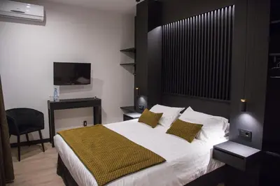 a bedroom with a large bed and a television at Elite Hotel - Gay Men Only in Sitges