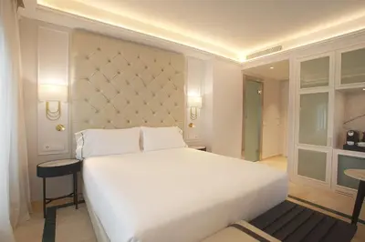 a bedroom with a large white bed and two tables at Eurostars Laietana in Barcelona