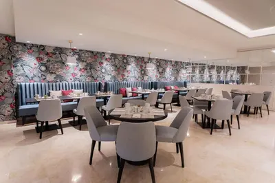 a dining room with tables and chairs and floral wallpaper at Eurostars Laietana in Barcelona
