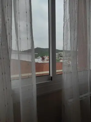 a window with white curtains and a view of a building at Apartamento en Viladecans cerca del aeropuerto in Viladecáns