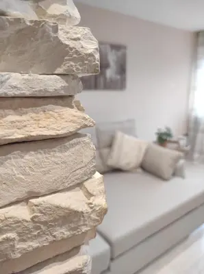 a living room with a couch and a stone wall at Apartamento en Viladecans cerca del aeropuerto in Viladecáns