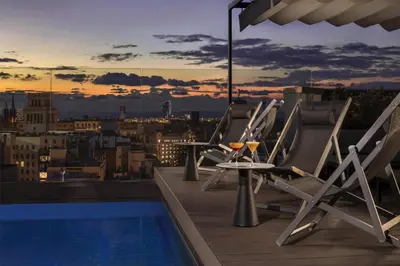 a group of chairs sitting on the roof of a building at NH Collection Barcelona Gran Hotel Calderon in Barcelona
