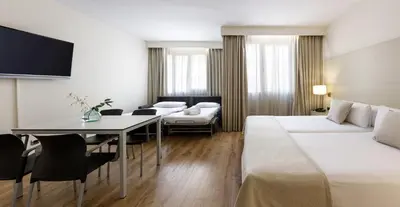 a bedroom with a bed with a bottle of wine and glasses at Aparthotel Mariano Cubi Barcelona in Barcelona