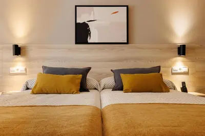 a bedroom with two beds with yellow pillows at Bonanova Park in Barcelona