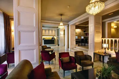 a living room with chairs and a chandelier at Hotel Condado in Barcelona