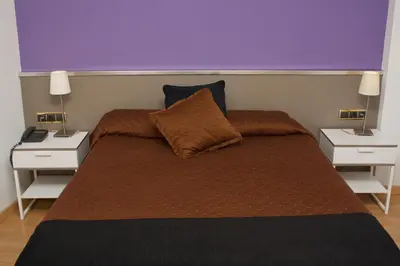 a bedroom with a bed with two night stands at Hotel Abbot in Barcelona