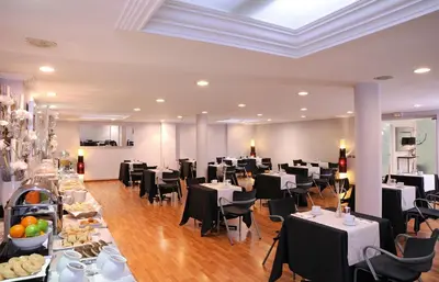 a dining room with tables and chairs in a room at Hotel Abbot in Barcelona