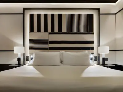 a bedroom with a large white bed with two lamps at H10 Marina Barcelona in Barcelona