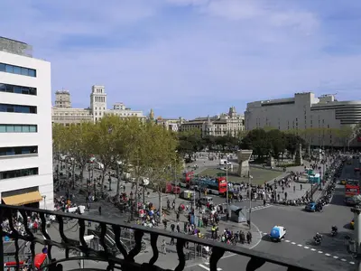 a crowd of people walking around a plaza in a city at Hotel Monegal in Barcelona