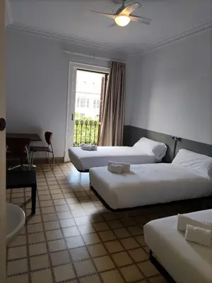 a hotel room with two beds and a window at Hotel Monegal in Barcelona