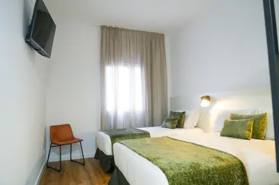 a hotel room with two beds and a tv at htop BCN City #htopEnjoy in Barcelona