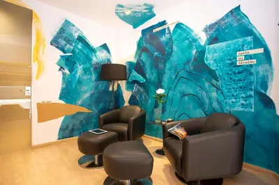 a room with two chairs and a blue wall at Casual Colours Barcelona in Barcelona