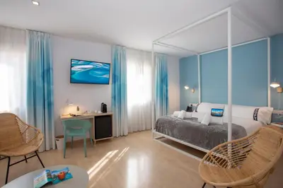 a bedroom with a bed and a desk and chairs at Casual Colours Barcelona in Barcelona