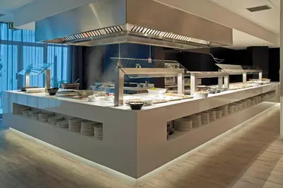 a restaurant with a counter with plates and food at Hotel Bernat II 4*Sup in Calella