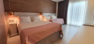 a hotel room with two beds and a window at Hotel Bernat II 4*Sup in Calella