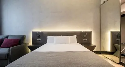 a bedroom with a bed and a couch at Ilunion Bel-Art in Barcelona