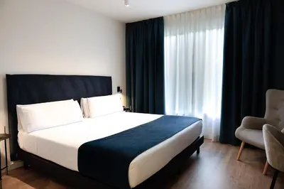 a hotel room with a bed and a chair at Arenas Atiram Hotel in Barcelona