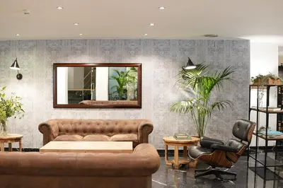a living room with a couch and two chairs and a mirror at Arenas Atiram Hotel in Barcelona