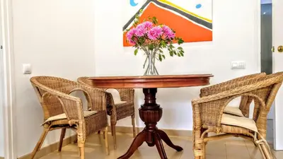 a dining room table with a vase of flowers on it at BizFlats Garden House in Barcelona