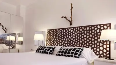 a white bedroom with a large bed with two pillows at BizFlats Garden House in Barcelona