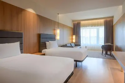 a hotel room with two beds and a couch at AC Hotel Diagonal L'Illa by Marriott in Barcelona