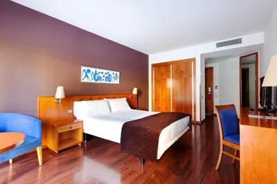 a hotel room with a bed and a table and chairs at Hotel Viladomat in Barcelona