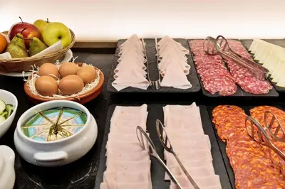 a table topped with different types of meats and vegetables at Hotel Best Aranea in Barcelona