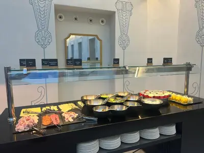 a buffet line with bowls of food and plates at Oriente Atiram Hotel in Barcelona