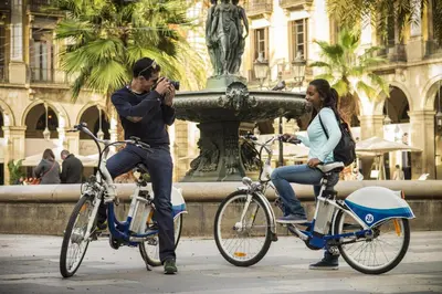 a man taking a picture of a woman on a bike at Oriente Atiram Hotel in Barcelona