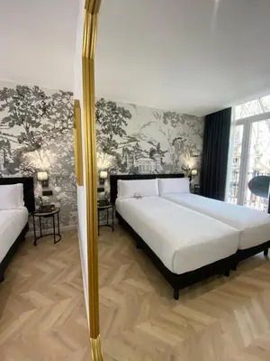 a bedroom with two beds and a wall with flowers at Oriente Atiram Hotel in Barcelona