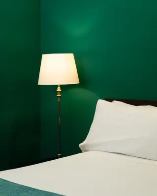 a bedroom with a green wall and a bed with a lamp at Hotel Ramblas Internacional in Barcelona