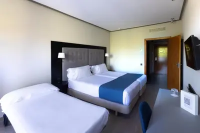 a hotel room with two beds and a tv at Abba Garden in Barcelona