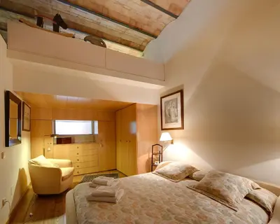 a bedroom with a large bed and a chair at Habitat Apartments La Bohème in Barcelona