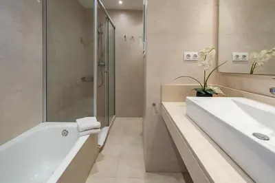 a bathroom with a tub and a shower and a sink at Habitat Apartments Tessa in Barcelona