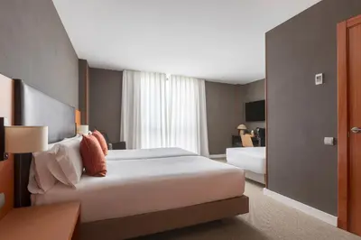 a hotel room with a large bed and a window at Acta Sant Just in Sant Just Desvern