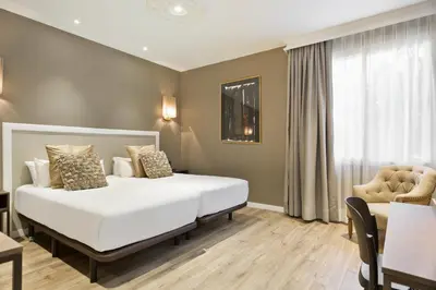 a bedroom with a large white bed and a chair at Acta Splendid in Barcelona