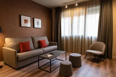 a living room with a couch and a table at Atenea Rekord Suites Barcelona in Barcelona