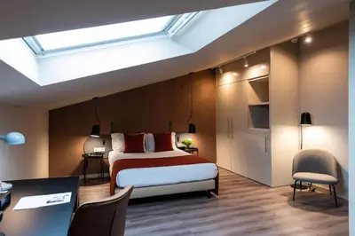 a bedroom with a bed and a skylight at Atenea Rekord Suites Barcelona in Barcelona